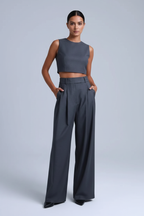 Woman wearing grey wide-leg virgin wool pants in editorial studio setting